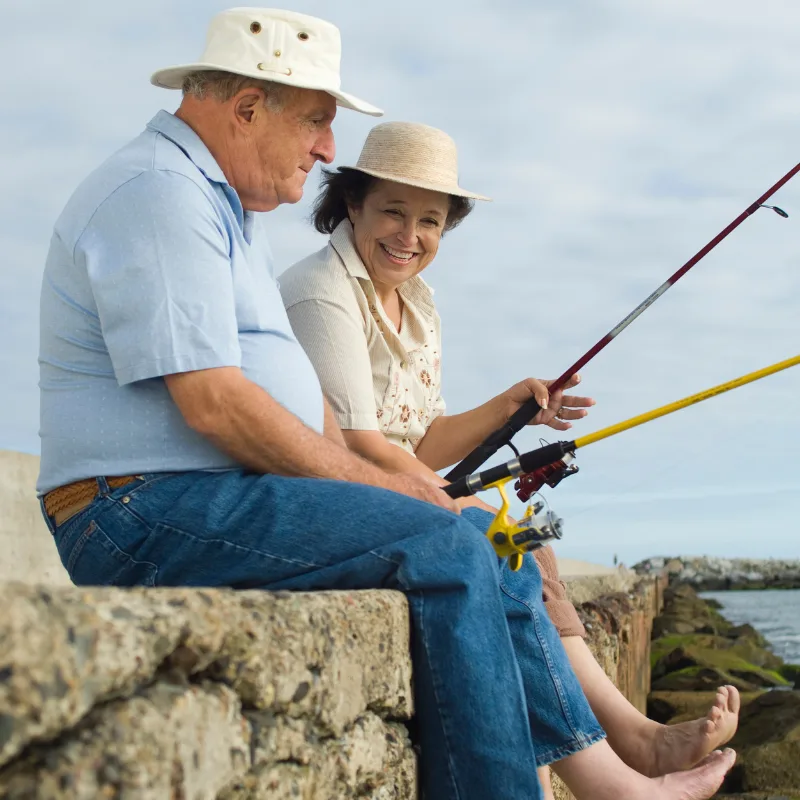 A couple fishing together by the water, enjoying retirement with calm and confidence
