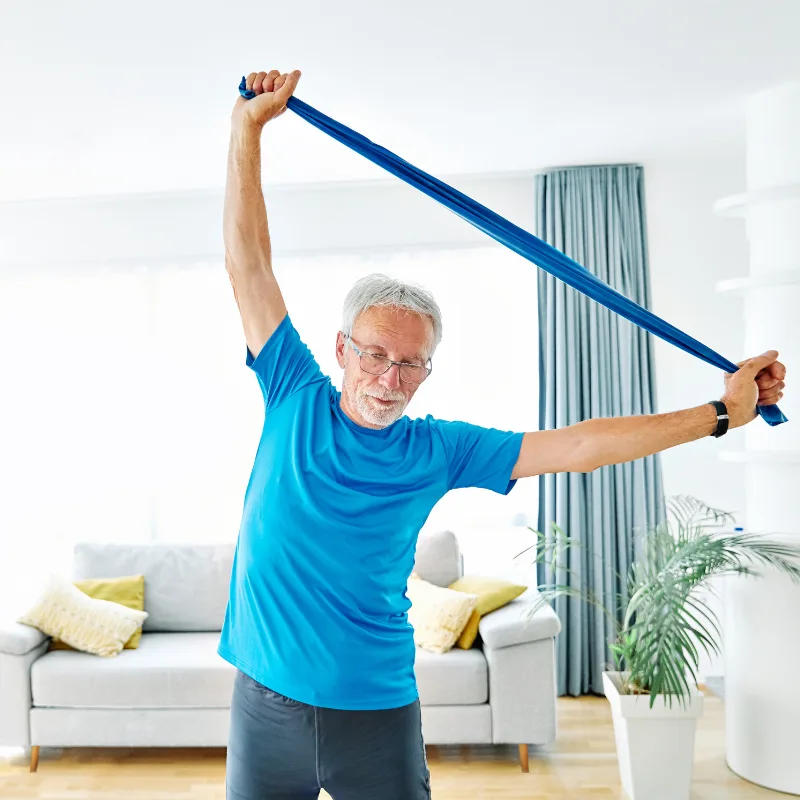 An older man doing resistance band exercises, active and healthy, showing that final expense coverage is available regardless of health status