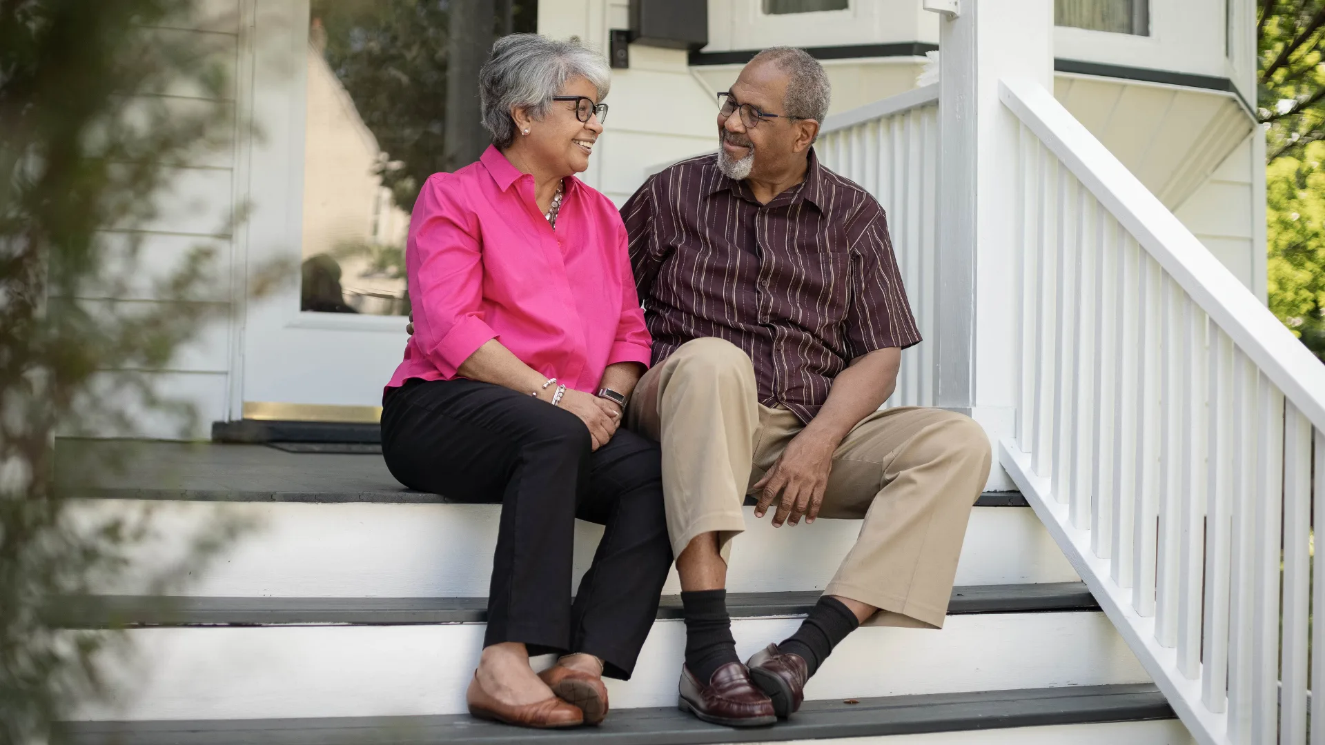 An older couple sitting together on a porch, relaxed and content, representing the peace of mind that comes with final expense coverage