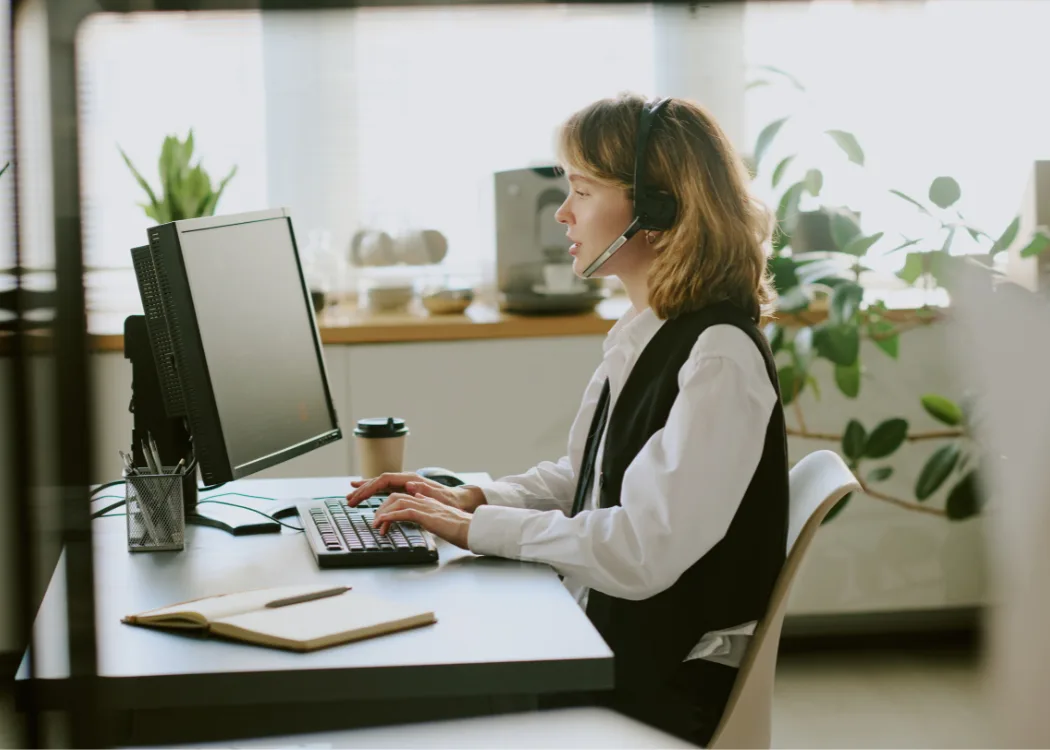 FCPC agent at her desk with headset and monitor, ready to assist