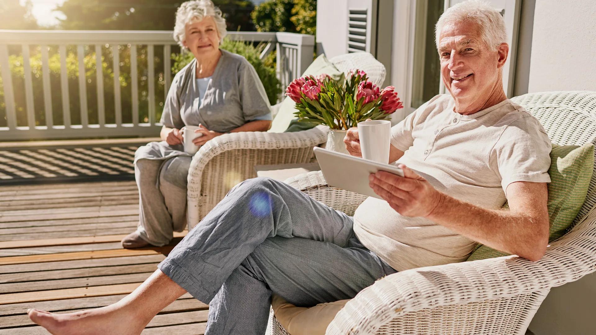 A couple relaxing together on a porch with coffee, looking content and at ease in retirement