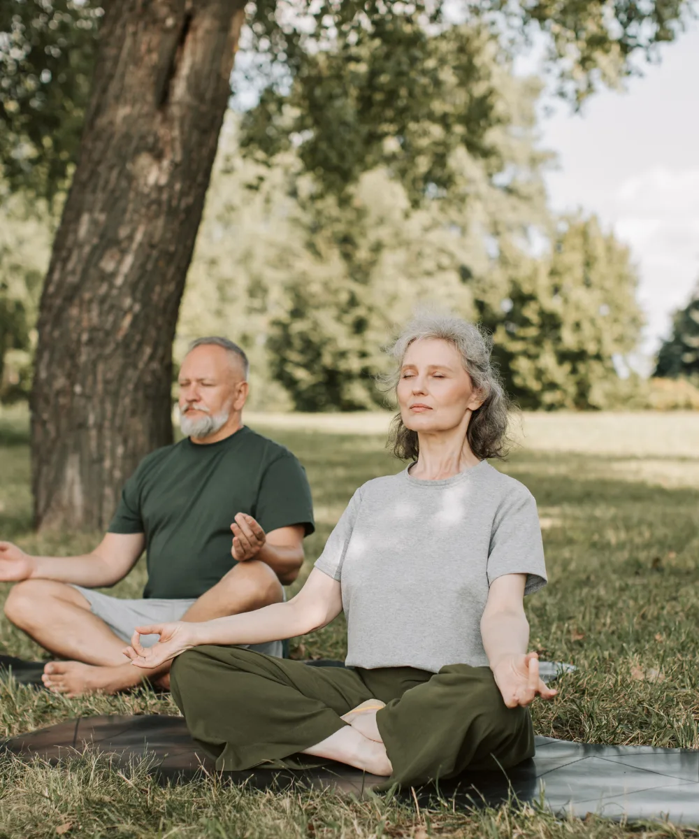 A couple meditating together outdoors, calm and at peace — representing the security of gains that lock in and never reverse