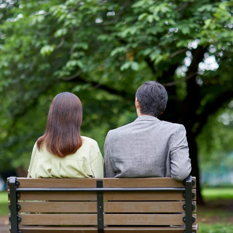 An older couple sitting peacefully on a park bench, representing the dignity and peace of mind that terminal illness coverage provides