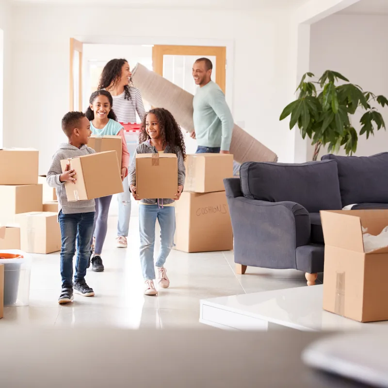 A family carrying boxes and belongings into their new home, representing the growth potential and lifelong protection of Indexed Universal Life insurance