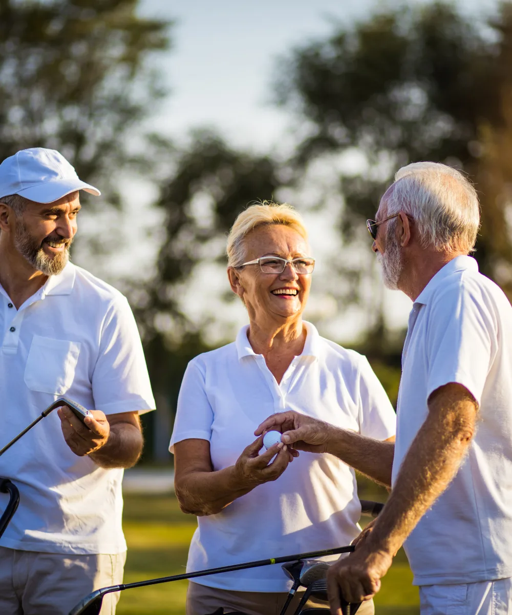 Two retired friends enjoying a round of golf together on a sunny course, representing the financial freedom and flexibility that life insurance cash value can provide in retirement