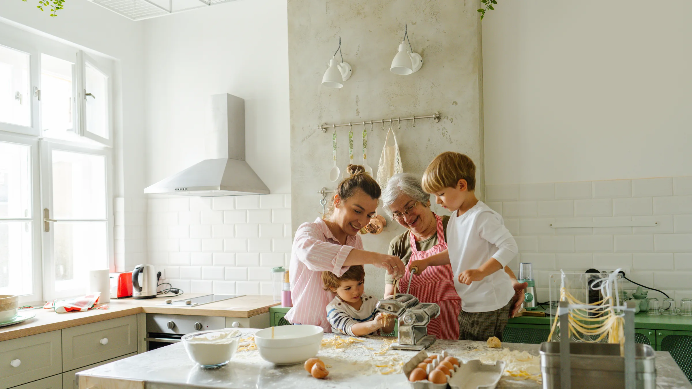 A family — two adults and two children — relaxing comfortably at home together, smiling and at ease