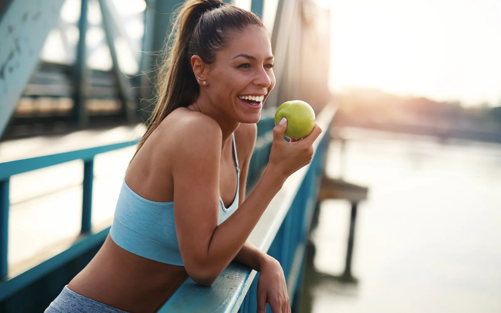 A person smiling with a healthcare professional in a bright clinical setting, representing supplemental health and cancer coverage that goes beyond standard insurance