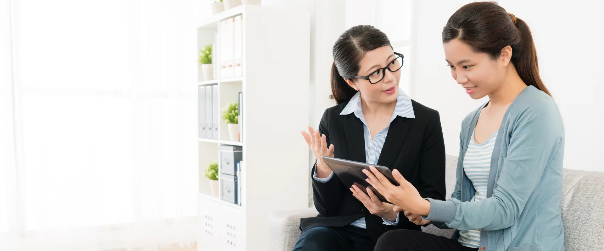 A financial agent reviewing tablet with a client, discussing supplemental health coverage options