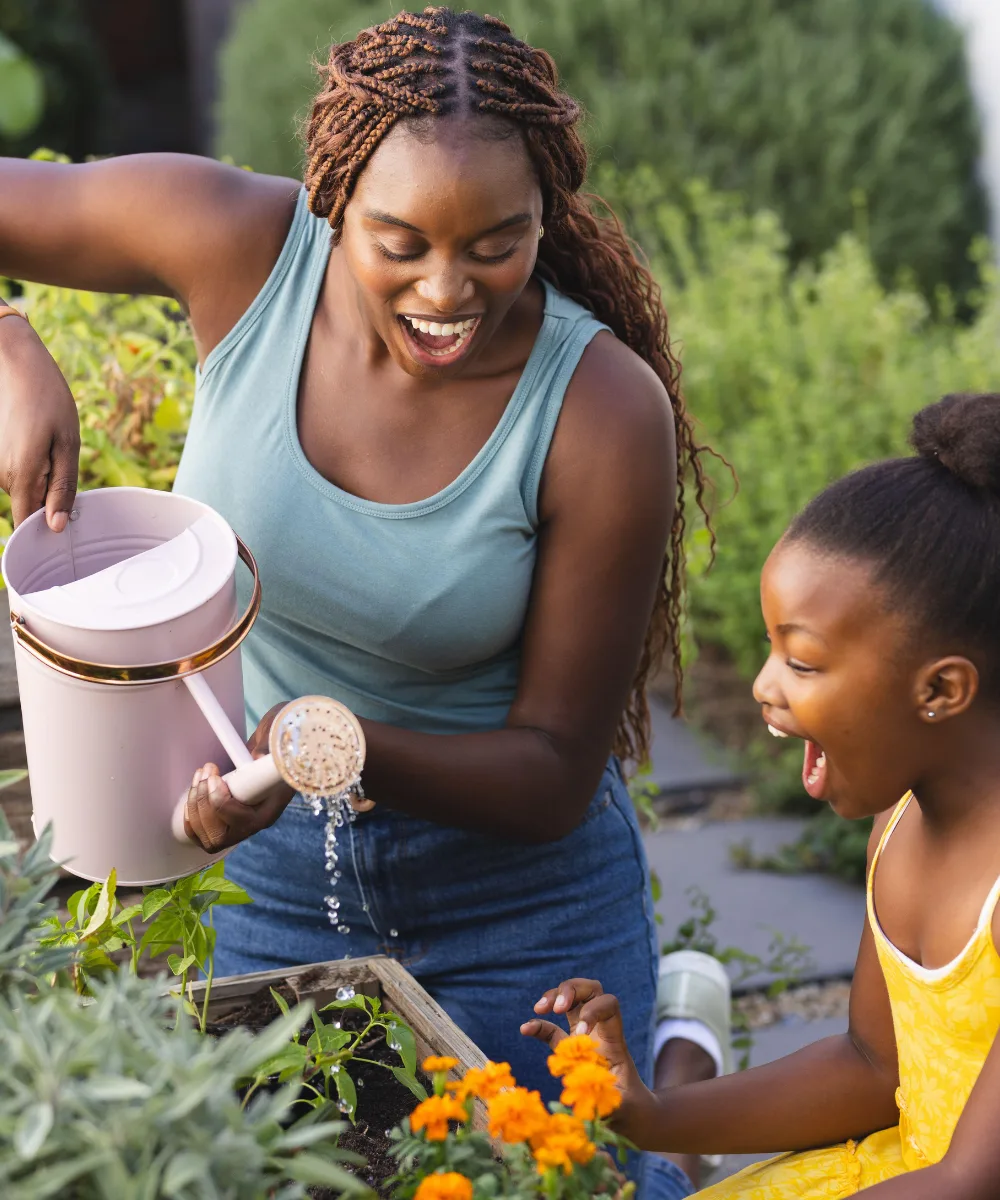 A mother and daughter gardening together, representing the steady growth of whole life cash value over time