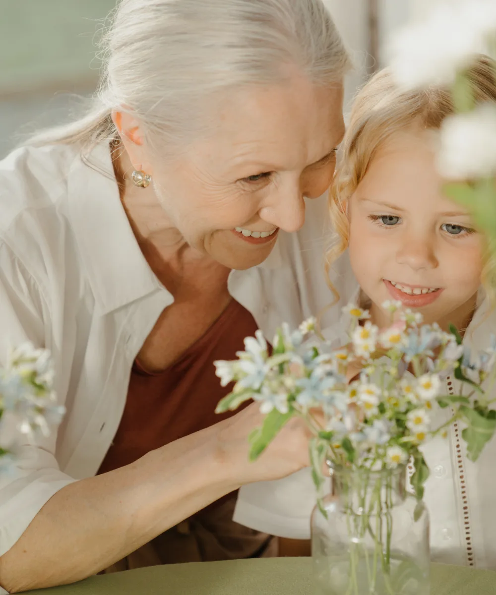 A grandmother and granddaughter together with flowers, representing the generational protection whole life provides