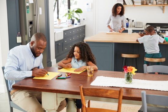 Young black family busy in their kitchen, elevated view